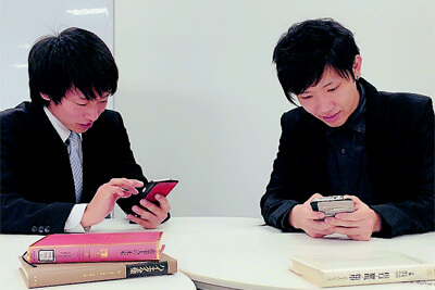 課外学習中にHandbookで資料確認する学生:イメージ