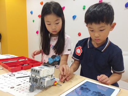 Handbookで配信されたタブレットのテキストを見ながら授業を受ける子どもたち(イメージ)